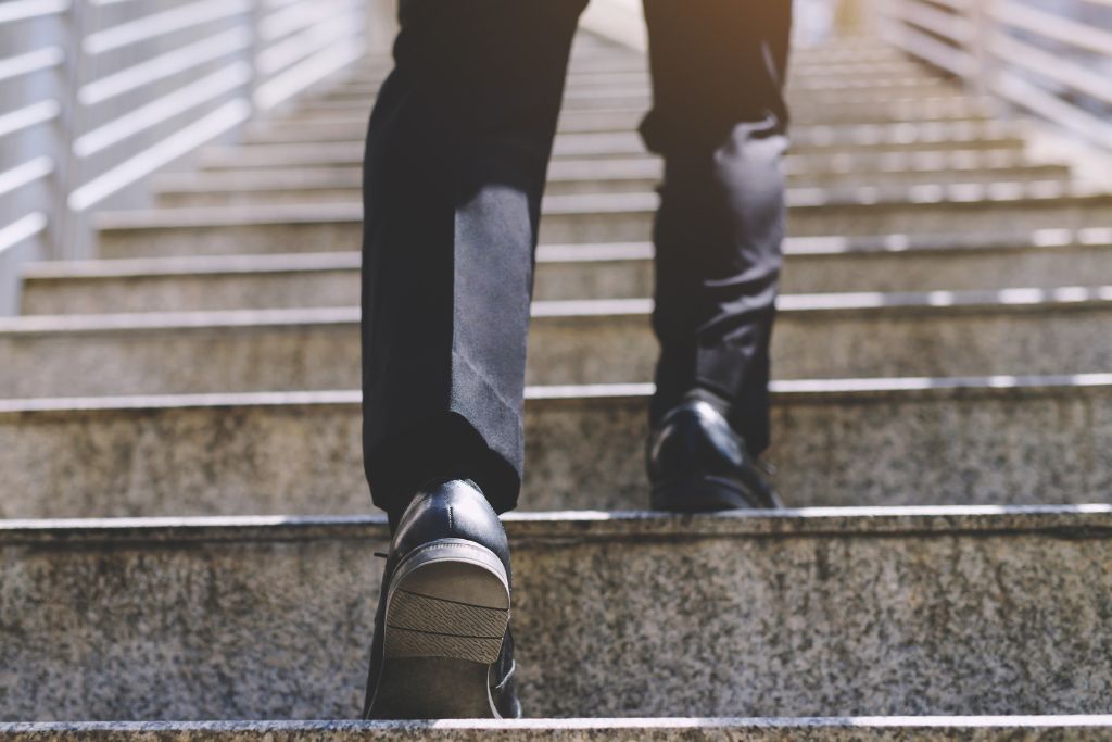 A man walking up a staircase - the 4 treatments of alcoholism - Which Rehab