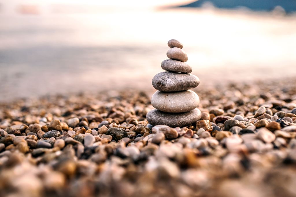A stack of pebbles on a beach - - the 4 treatments of alcoholism - Which Rehab